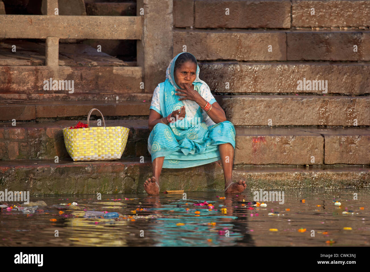 Alte indische Frau Reinigung ihrer Zähne mit Finger in schmutzigen verschmutzte Wasser des Flusses Ganges in Varanasi, Uttar Pradesh, Indien Stockfoto