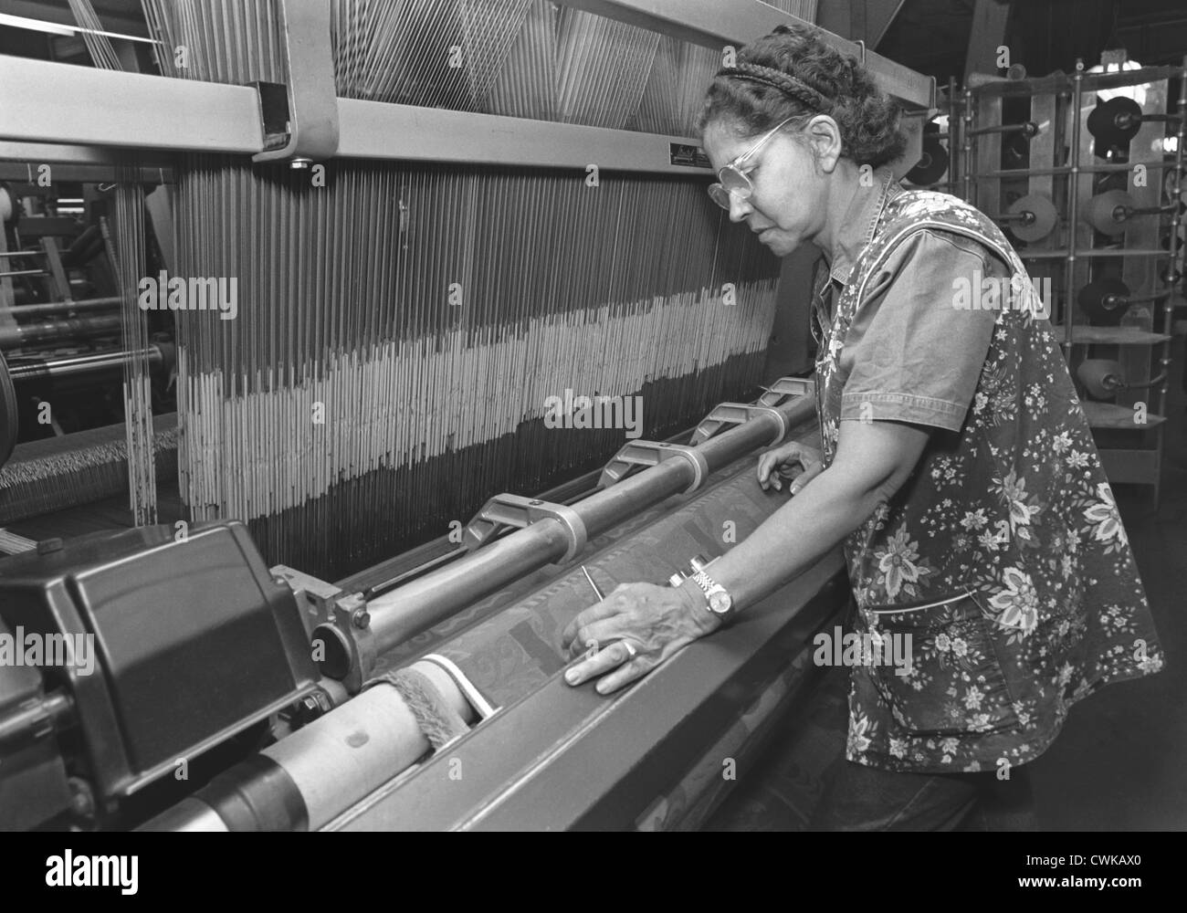 Eine Frau, Textilarbeiterin, arbeiten mit den Händen in einer Kleidung und Stoff. Stockfoto