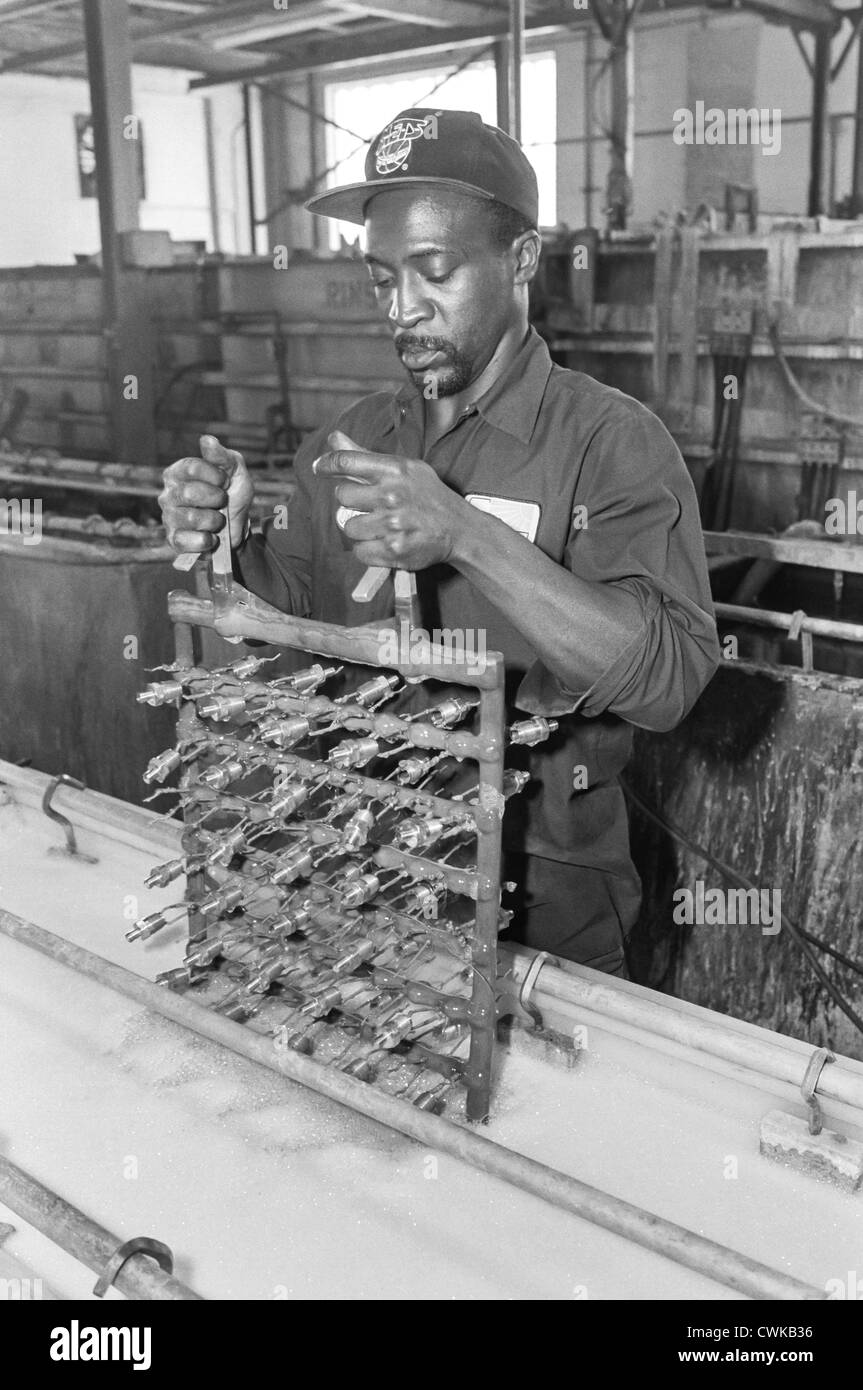 Ein Mann, blaue Kragen Arbeiter, mit seinen Händen in einer Fabrik arbeiten. Stockfoto