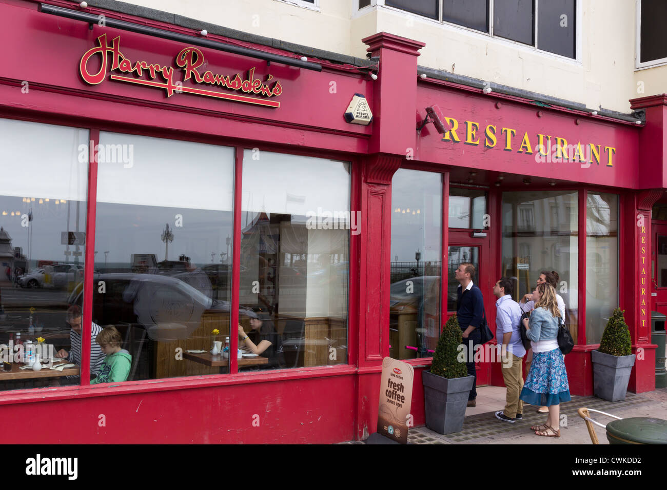 Menschen Essen und Blick auf die Speisekarte an Harry Ramsdens Brighton Stockfoto
