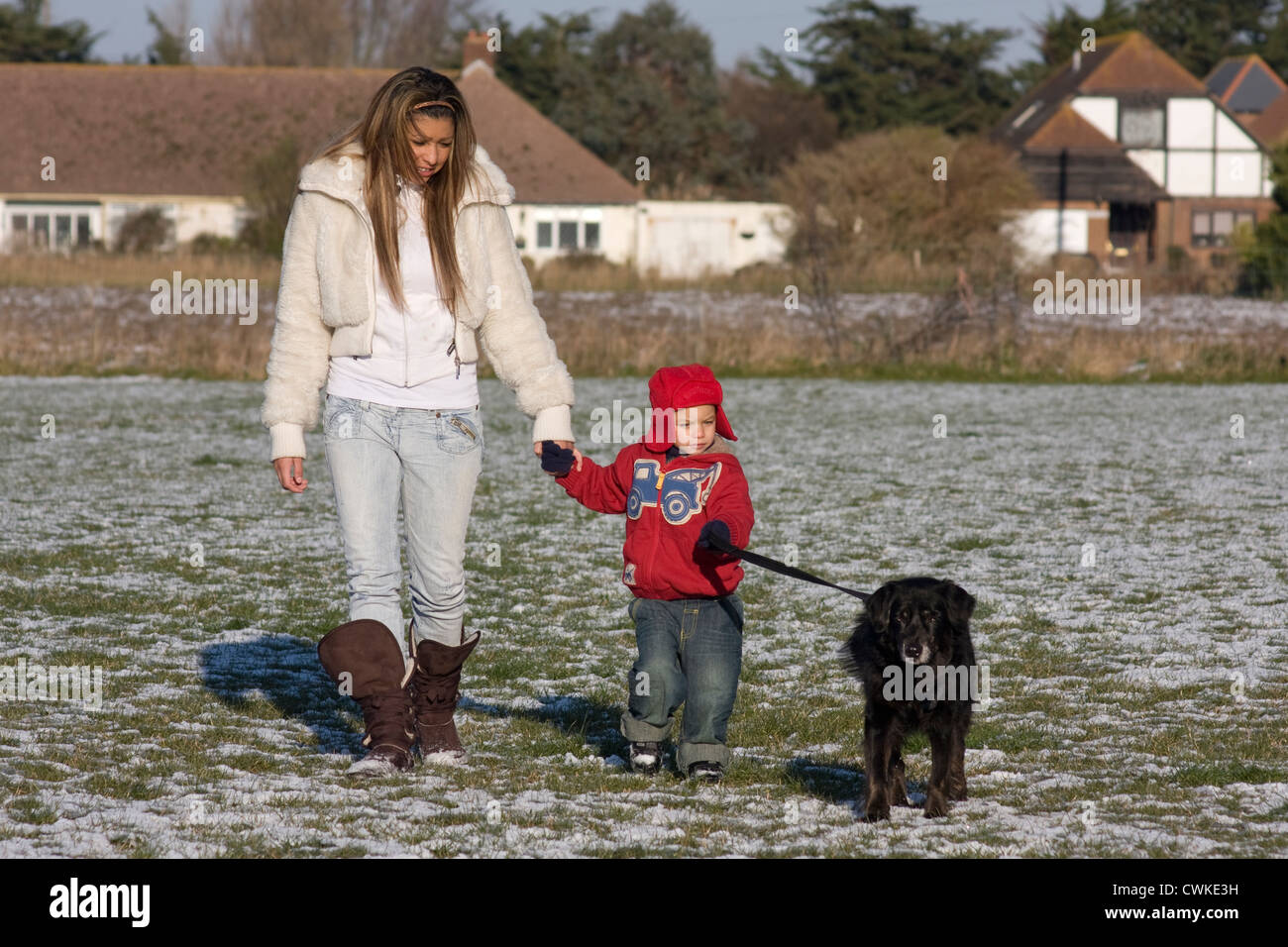 Mutter, Kleinkind und Hund im Schnee Stockfoto
