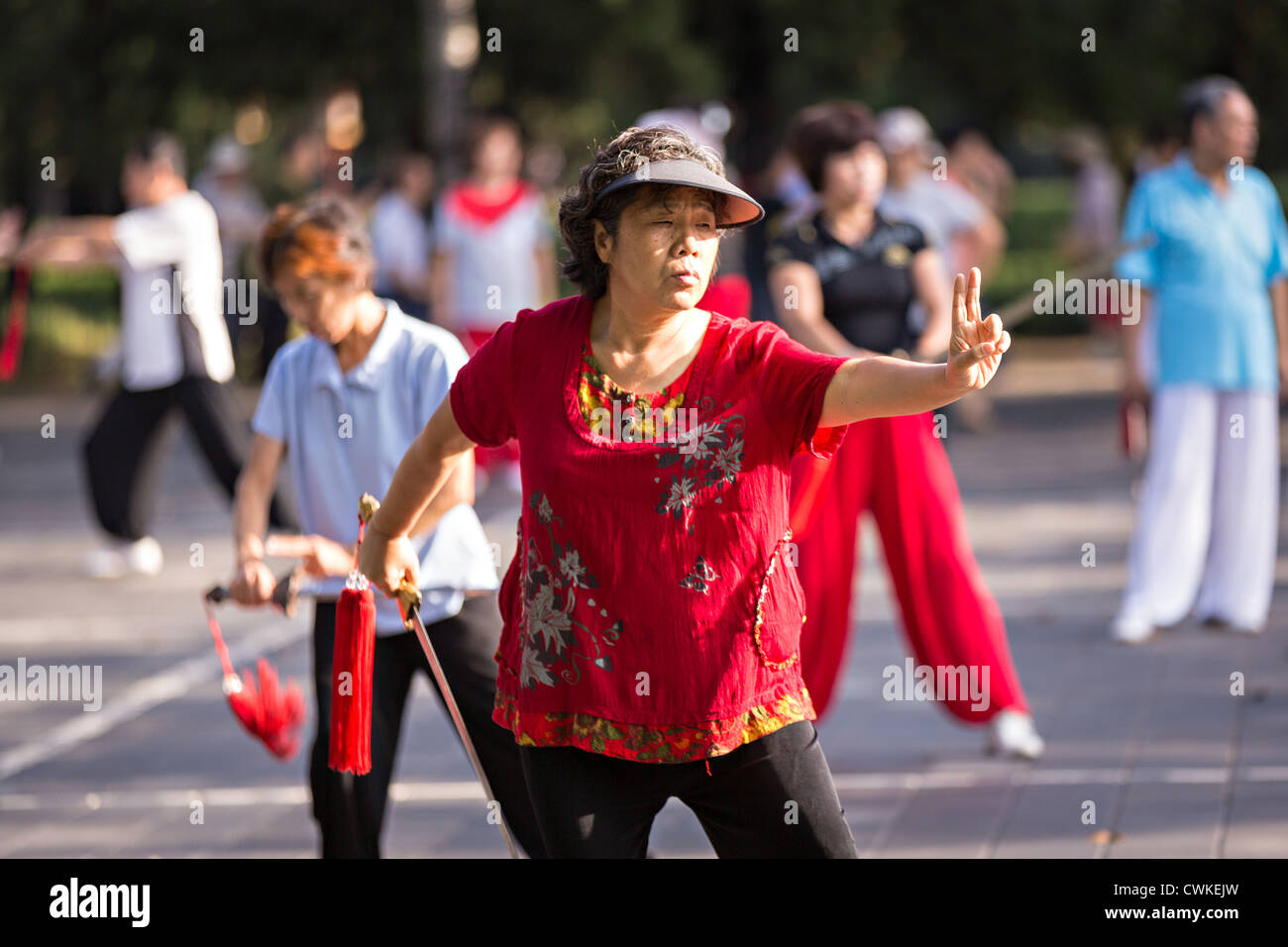 Ältere chinesische Frauen Praxis Schwert Martial Arts trainieren Sie am frühen Morgen im Tempel des Himmels Park im Sommer in Peking Stockfoto