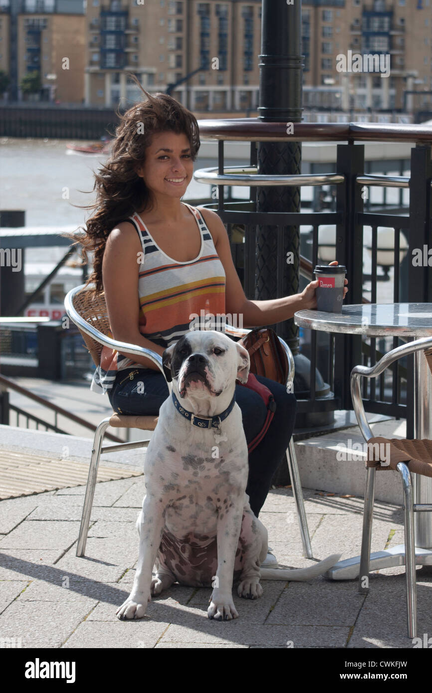 junge Frau mit Hund, draußen Café trinken Kaffee, Canary Wharf, London Stockfoto