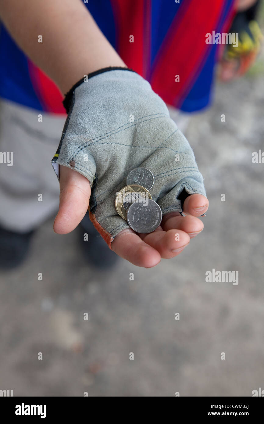 Junge 8 Jahre halten polnische Münzen in seine Fahrrad fingerlose Handschuhe. Rzeczyca Zentralpolen Stockfoto