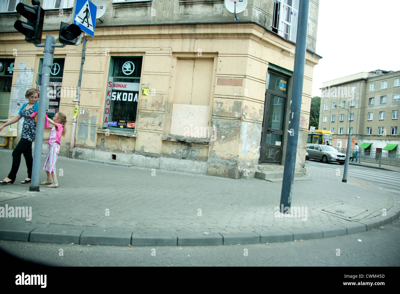 Mama und Kind drücken die Schaltfläche "Spaziergang", überqueren Sie die Straße mit Werbung für Skoda auto-Fenster. Lodz Polen Stockfoto