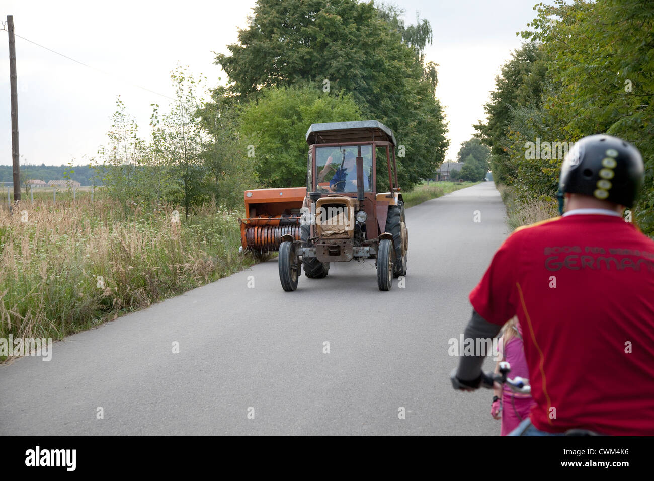 Polnischen Traktor Clipping wieder Unkraut entlang der Schulter der Straße. Zawady Zentralpolen Stockfoto