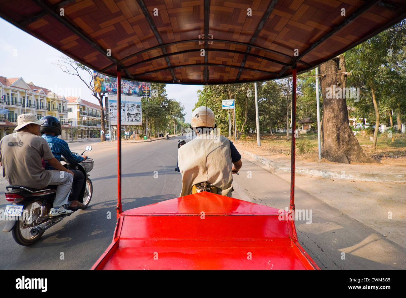 Horizontale Ansicht von innen ein Tuk-Tuk auf einer Straße in Kambodscha mit einem Motorrad fahren neben Reisen. Stockfoto