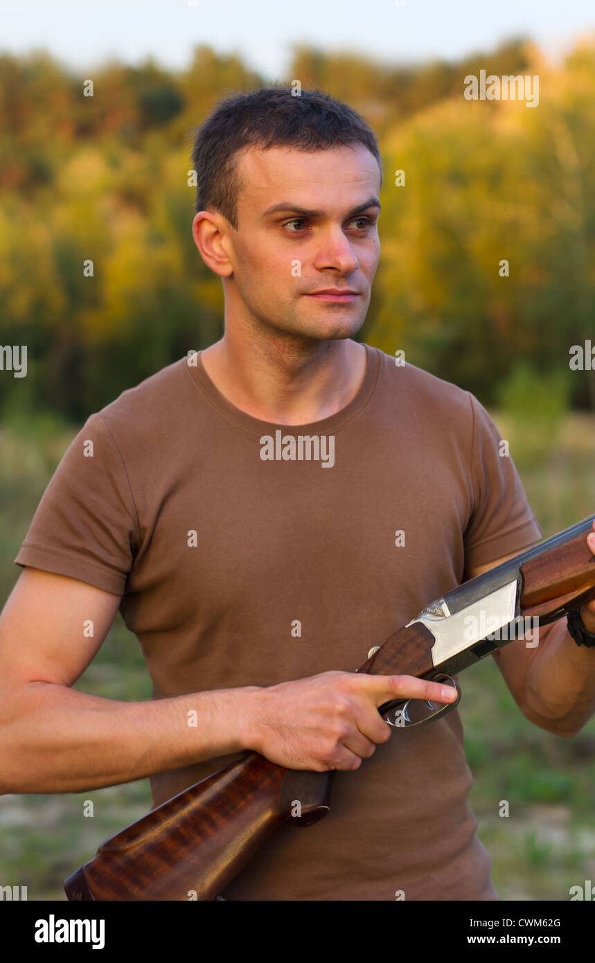 Ein junger Mann mit einem Gewehr für Trap-schießen Stockfoto