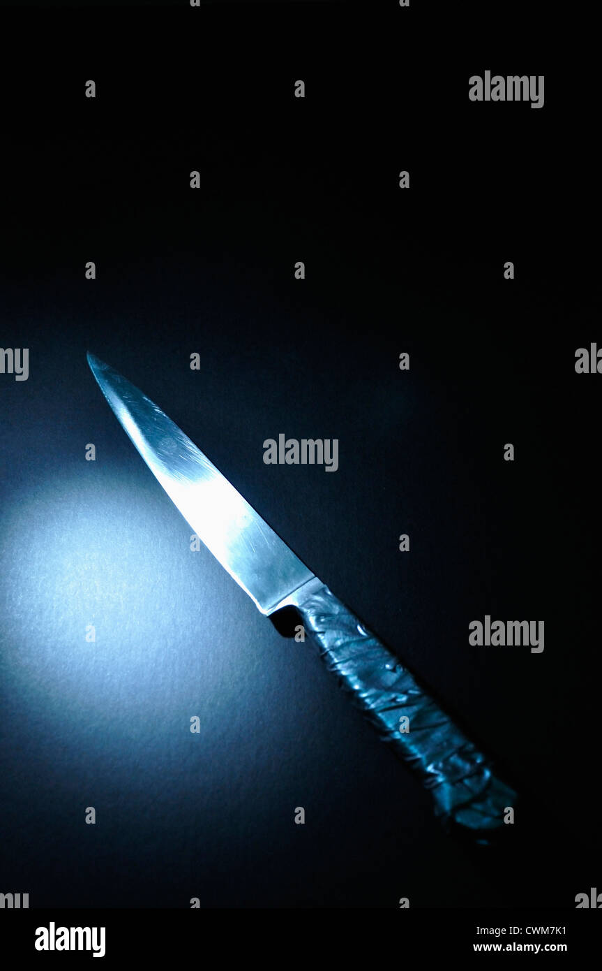 Messer mit blauen Spotlight auf schwarzem Hintergrund, Nahaufnahme Stockfoto