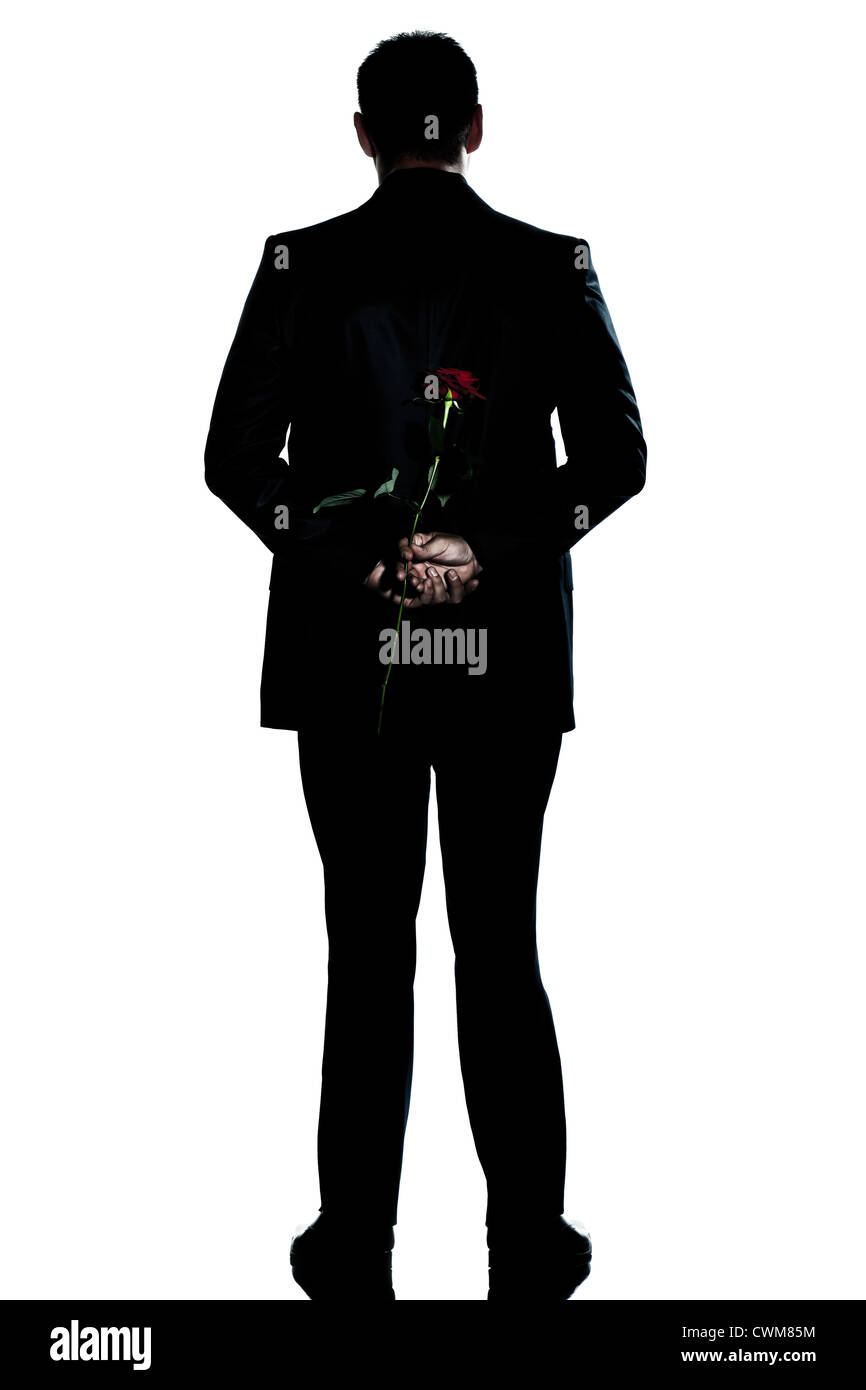 eine kaukasische Rückseite Mann hält eine rose Blume in voller Länge Silhouette im Studio isoliert weißen Hintergrund Stockfoto