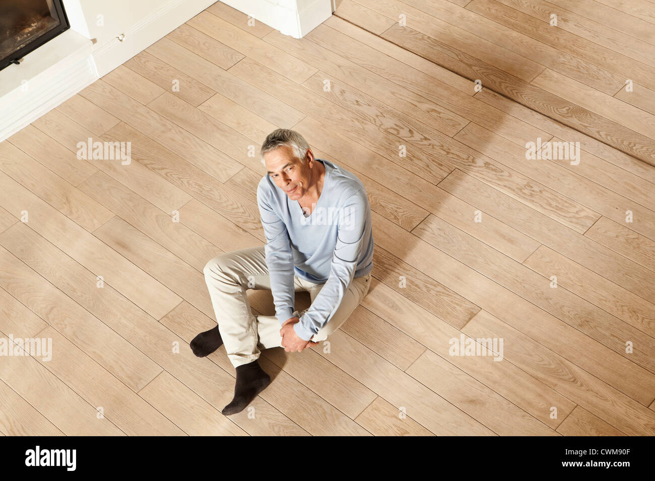 Deutschland, Berlin, Senior Mann sitzt am Boden, Porträt Stockfoto