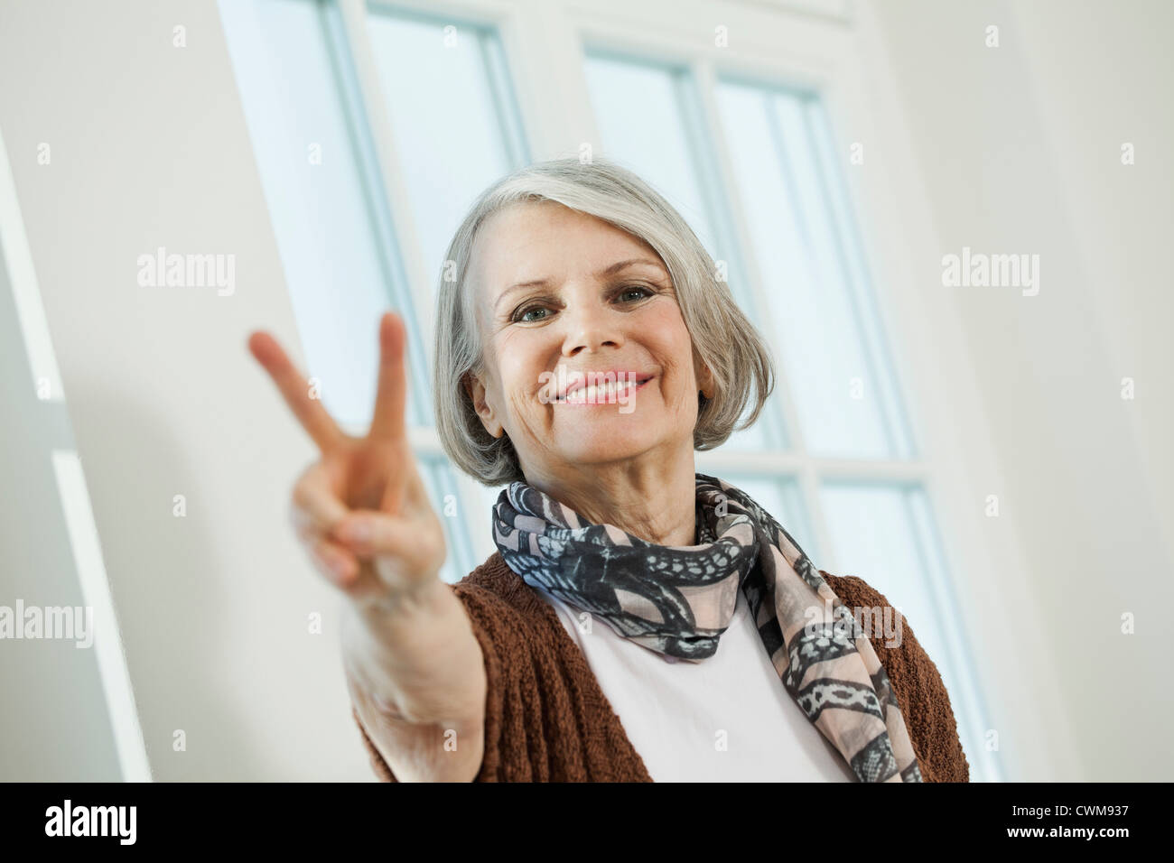 Deutschland, Berlin, ältere Frau, die Peace-Zeichen, Lächeln, Porträt Stockfoto