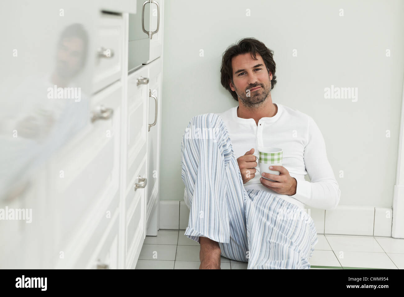 Deutschland, Berlin, reifer Mann mit Kaffeetasse in Küche, Porträt Stockfoto