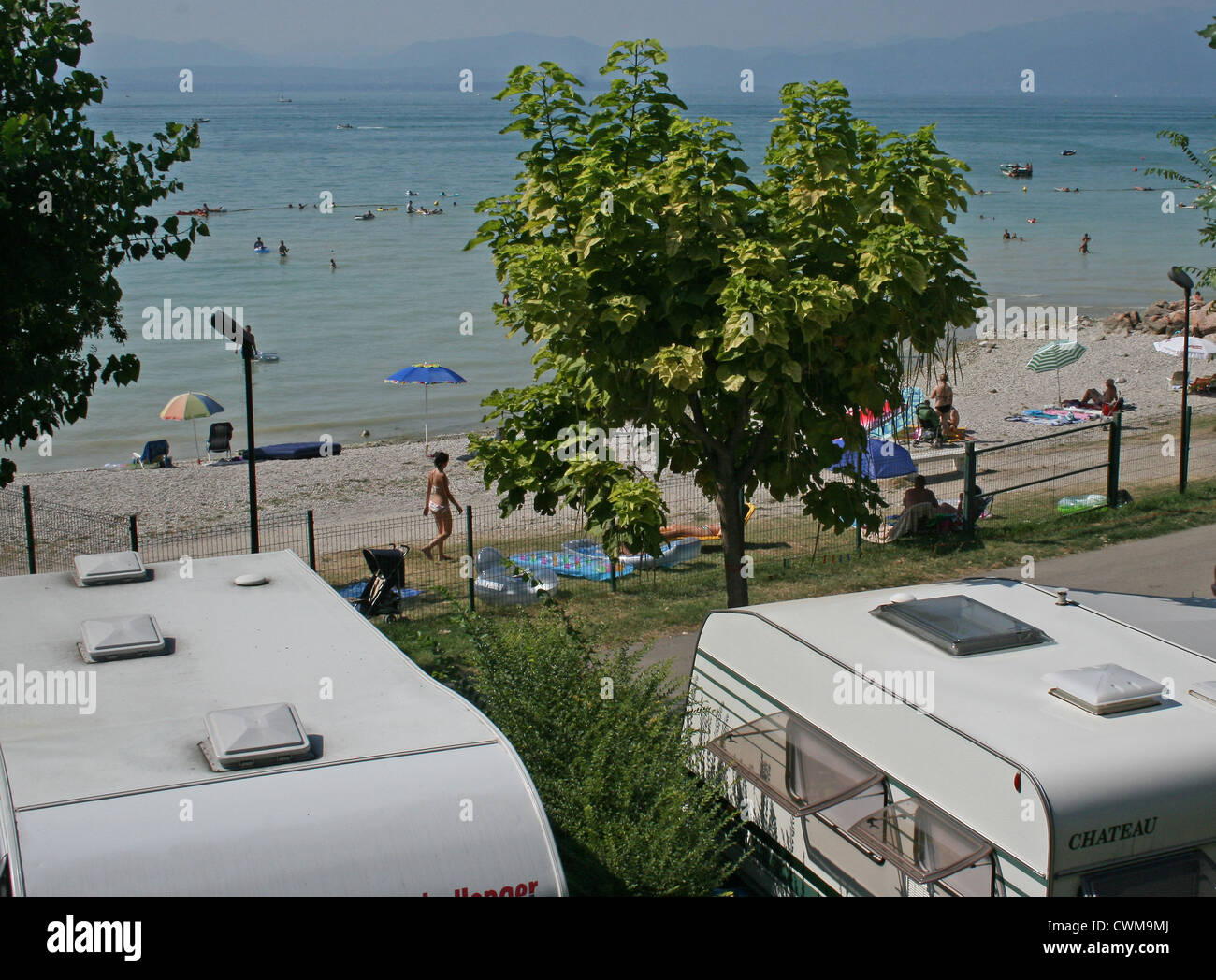 Wohnwagen geparkt neben dem Strand am Gardasee, Camping Lido, Pacengo, Italien, an einem heißen Sommertag im August Stockfoto