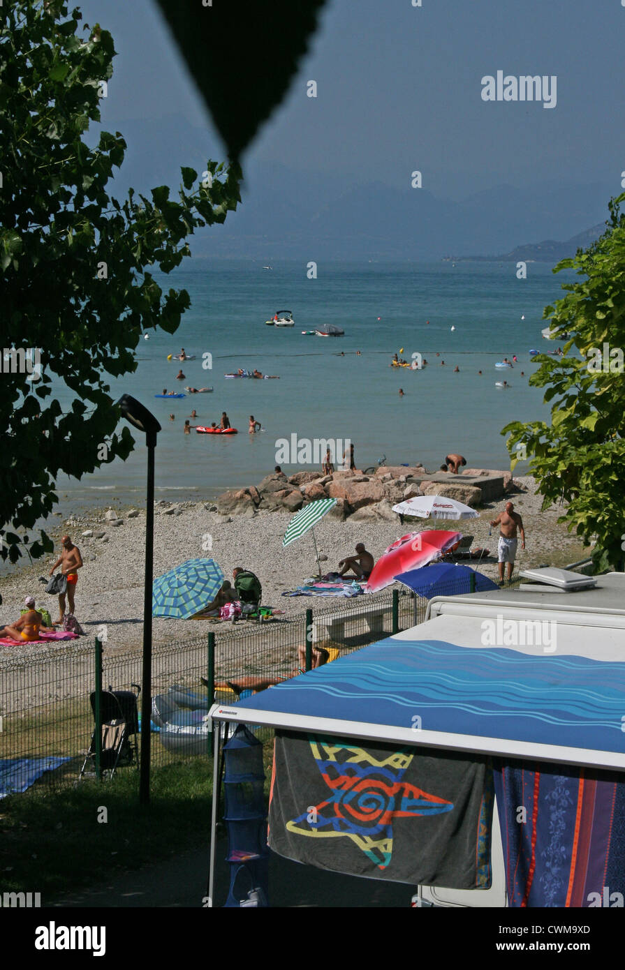 Wohnwagen geparkt neben dem Strand am Gardasee, Camping Lido, Pacengo, Italien, an einem heißen Sommertag im August Stockfoto