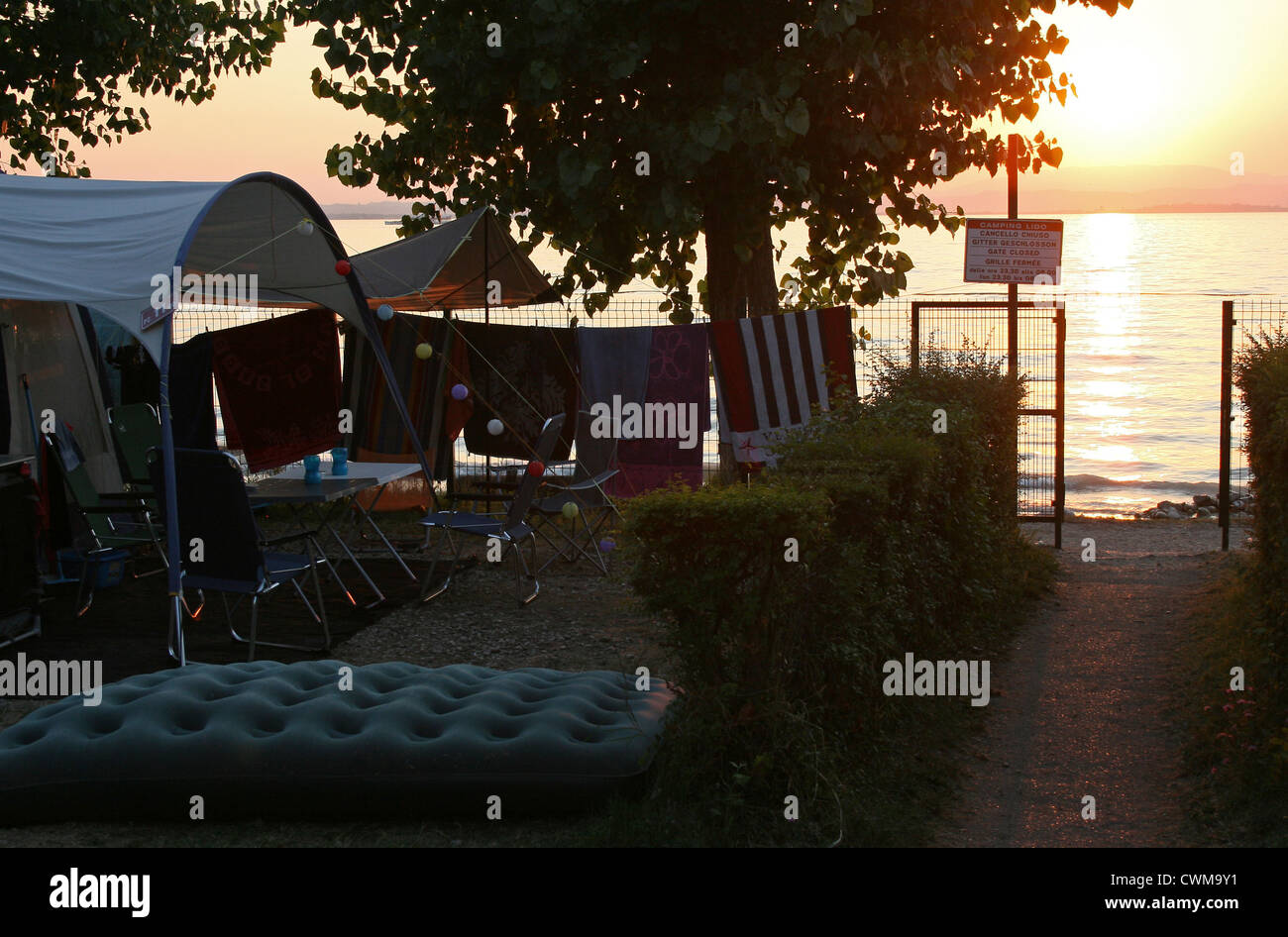 Wohnwagen geparkt neben Pacengo Gardasee, Camping Lido Italien bei Sonnenuntergang Stockfoto