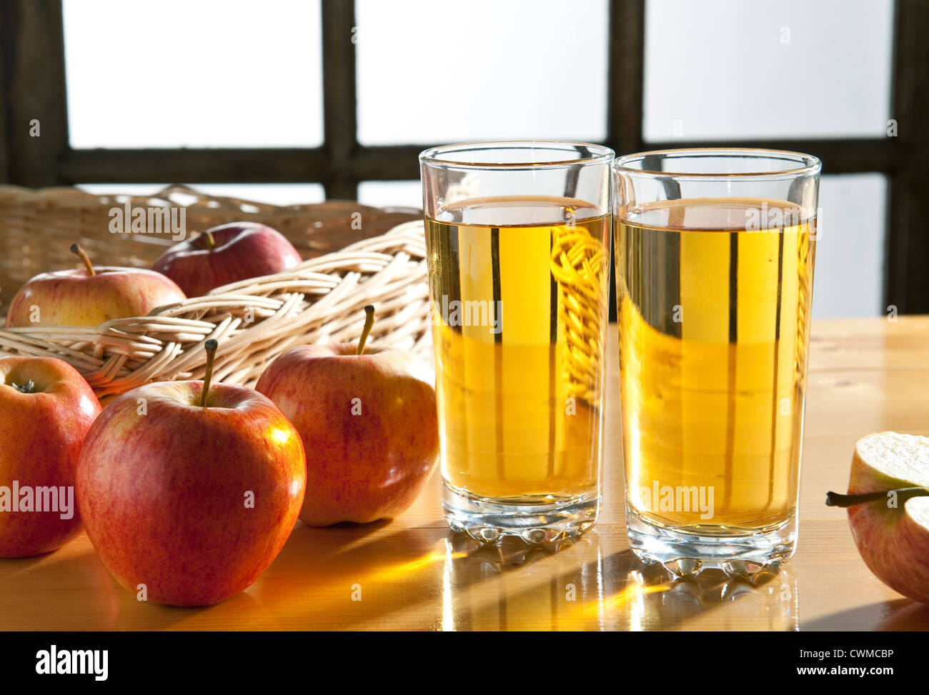 Apfelsaft - zwei Gläser Apfelsaft am Küchentisch, mit Äpfeln Stockfoto