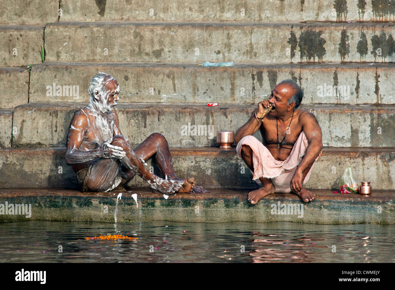 Indische Männer mit Seife waschen und Zähneputzen am Ghat entlang des heiligen Ganges, Varanasi, Uttar Pradesh, Indien Stockfoto