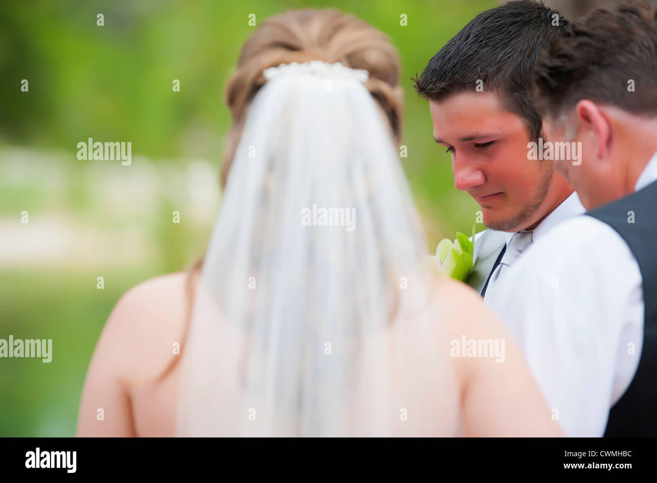 Braut und Bräutigam an ihre Hochzeit im freien beten. Stockfoto