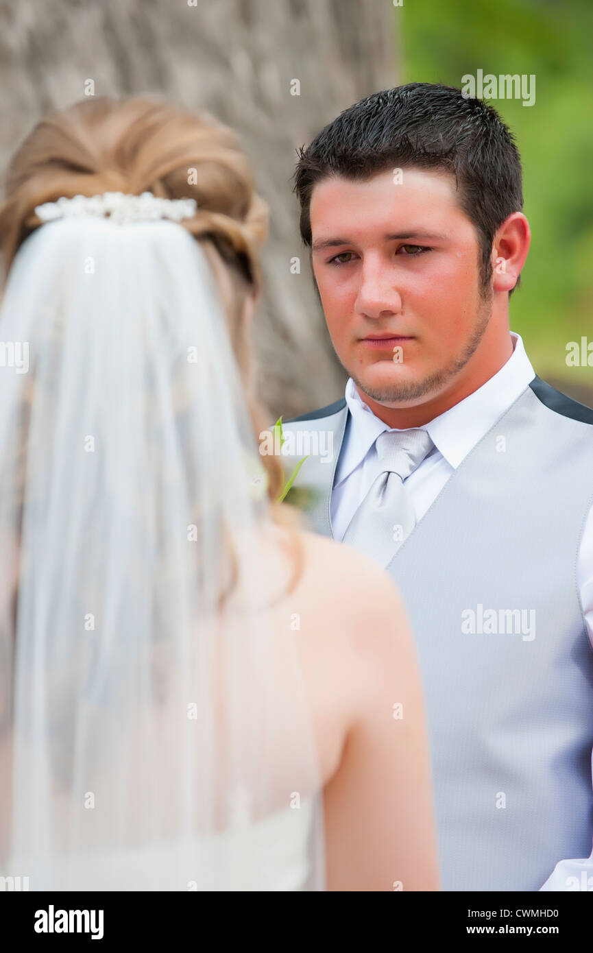 Junge Bräutigam die Braut bei einer Hochzeit im Freien in Texas, USA betrachten. Stockfoto