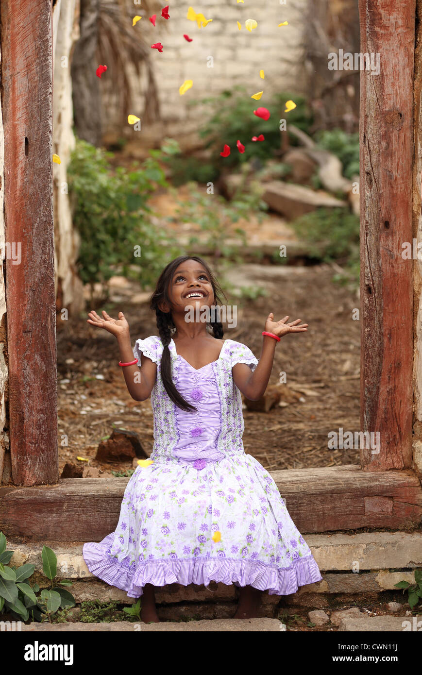 Junge Inderin ländlichen wirft Rosenblätter Andhra Pradesh in Indien Stockfoto