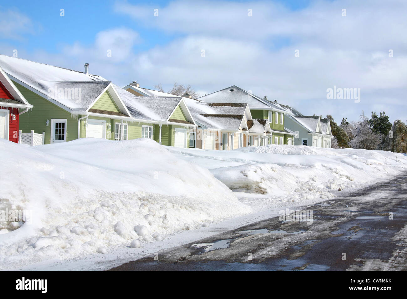 Eine Reihe von Stadthäusern mit Tiefschnee Banken weggedrückt Asphalt Straße. Stockfoto