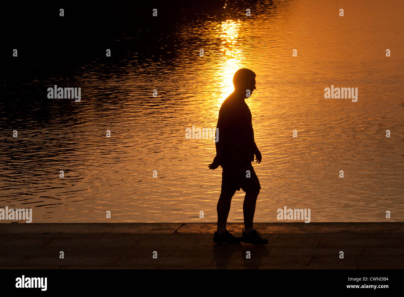 Mann zu Fuß vor der Lichtreflexion am frühen Morgen Stockfoto