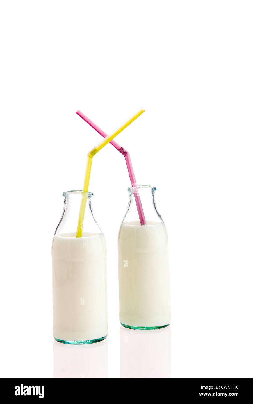 Milch in Flaschen mit einem Strohhalm, auf 100 % weißen Hintergrund isoliert Stockfoto
