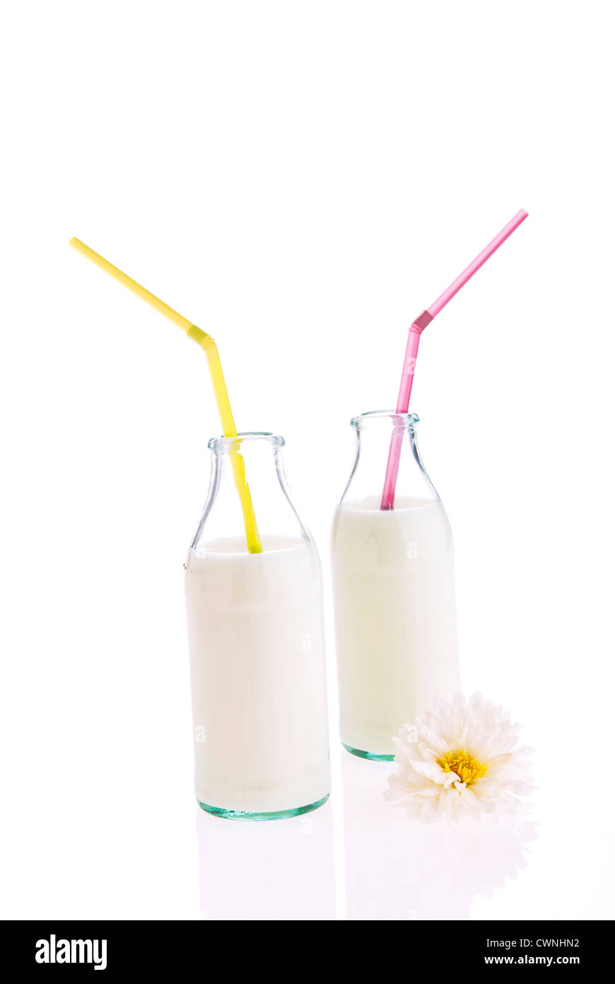 Milch in Flaschen mit einem Strohhalm, auf 100 % weißen Hintergrund isoliert Stockfoto
