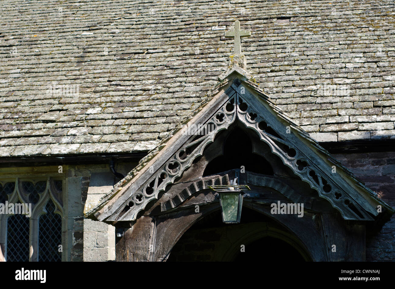 Eine alte, aus Holz Eiche Eingangshalle, mit einer alten, dekorativ geschnitzten gefliest Dach, was in zu einem 14. Jahrhundert Kirche. Stockfoto