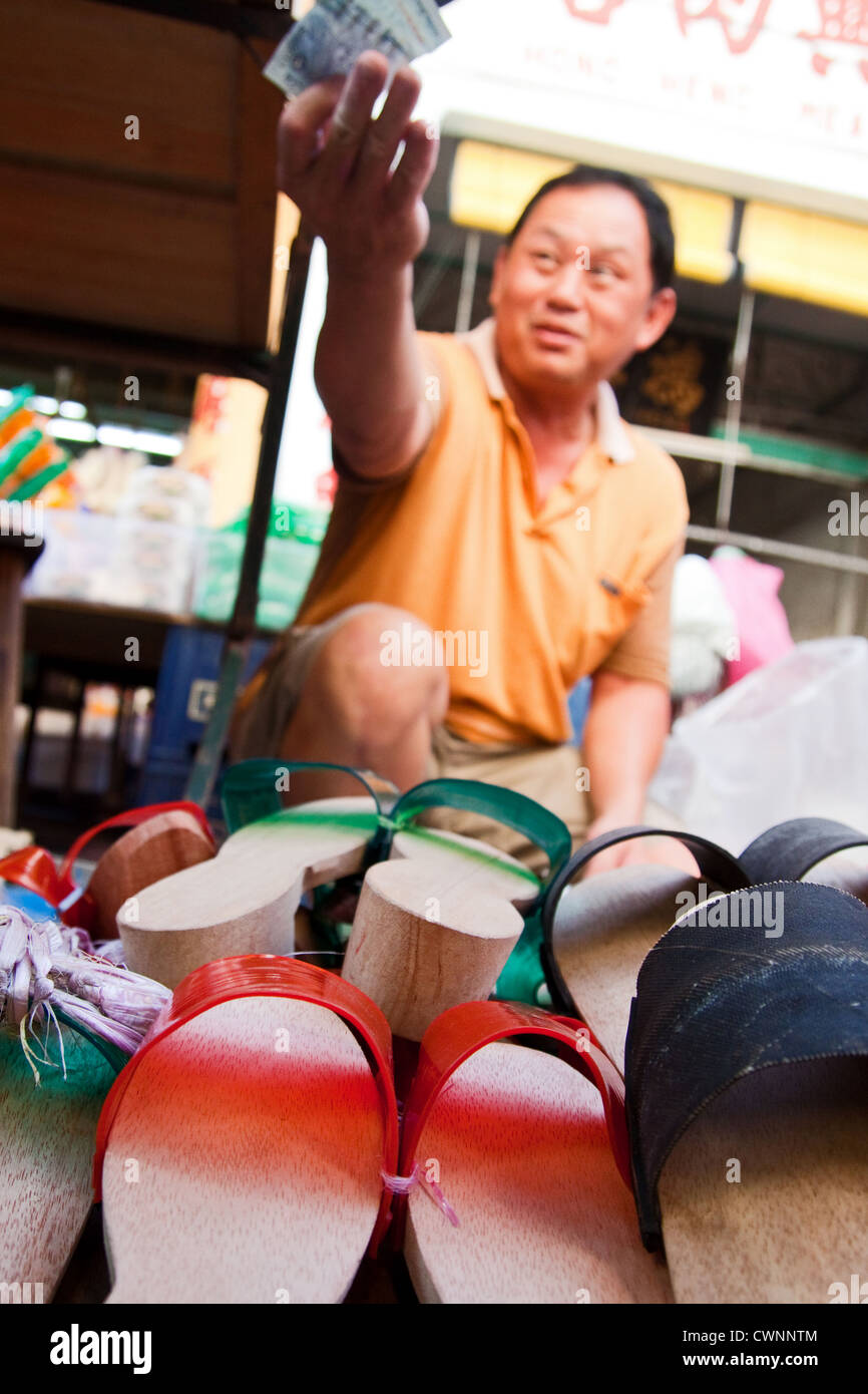 Schuh an Street Market auf der malaysischen Insel Penang mit chinesischen Händler Erfüllung Transaktion ausgeht. selektive Fokus auf Vorder- und Schuhe Stockfoto