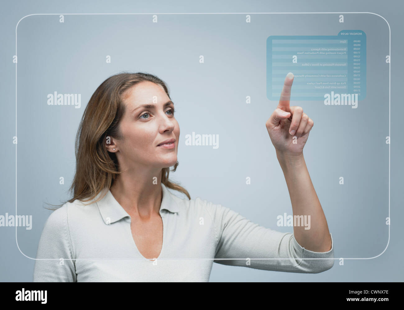 Frau betrachten ihr Tagesprogramm auf erweiterte Touch-Screen-Oberfläche Stockfoto