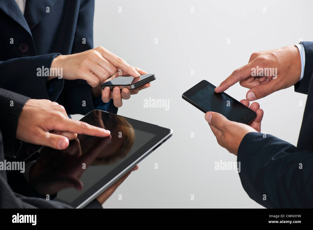 Kollegen, die Austausch von Informationen mit Smartphones und digital-Tablette, beschnitten Stockfoto