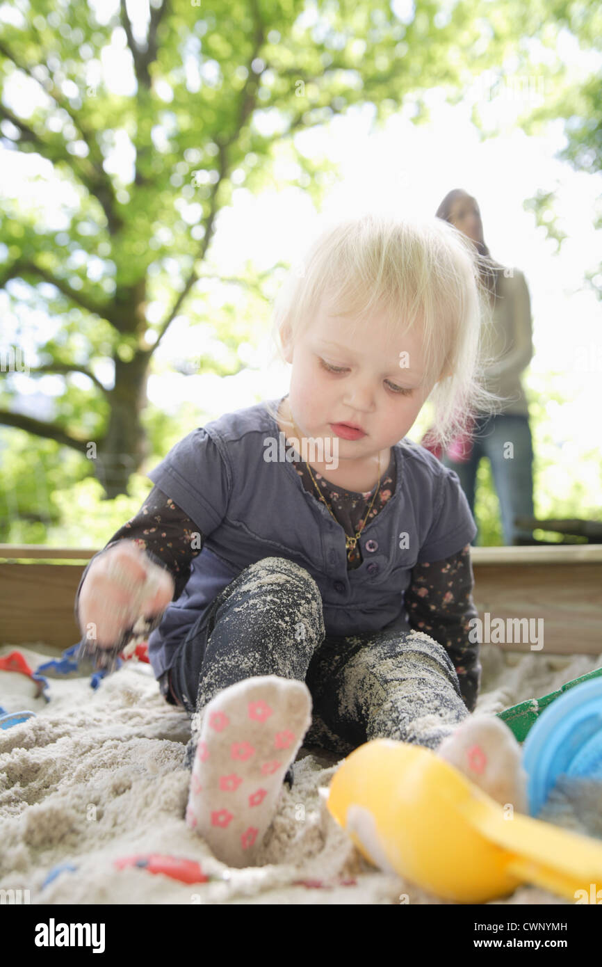 Deutschland, Bayern, Mädchen spielen im Sandkasten, Mutter gerade im Hintergrund Stockfoto