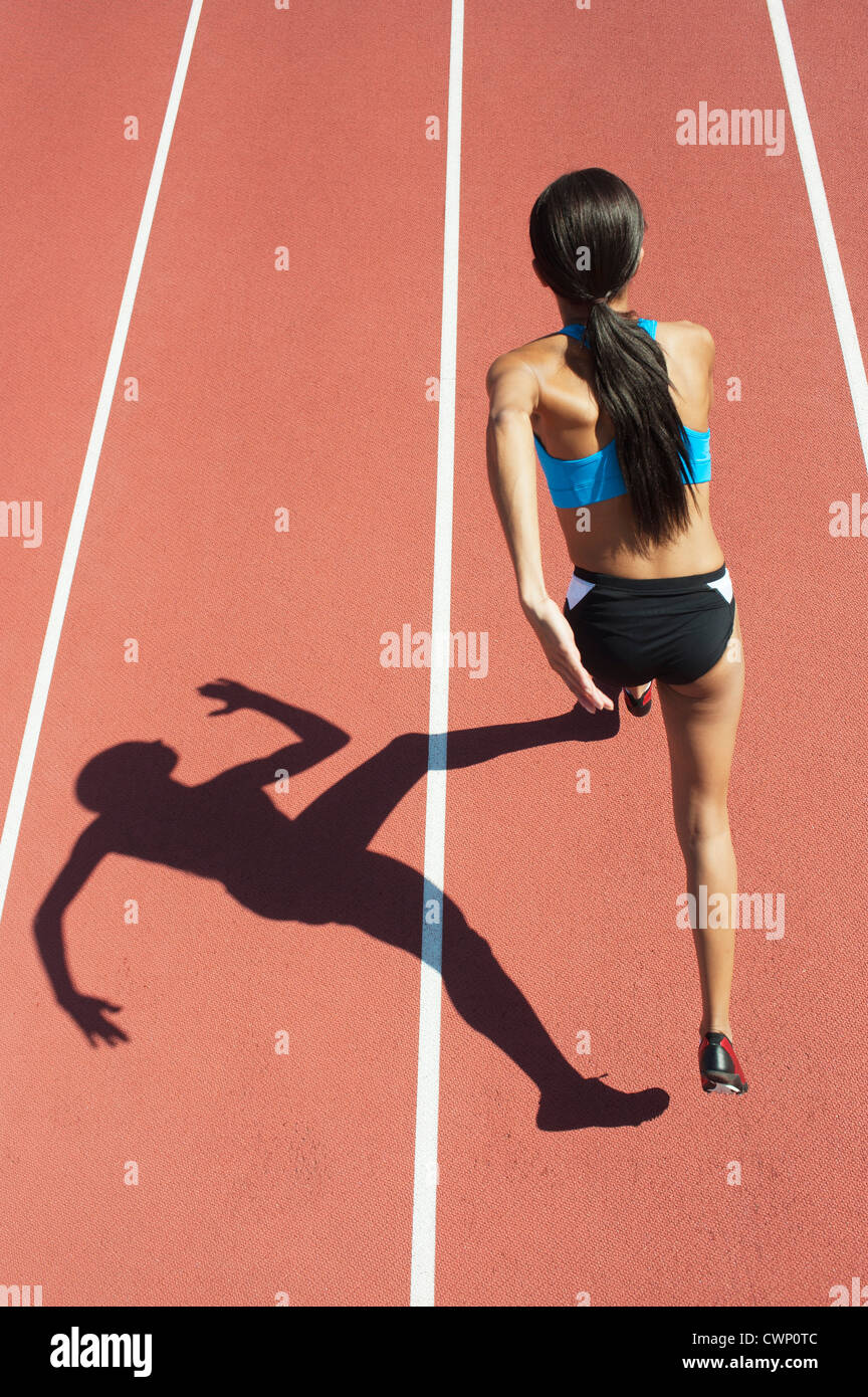 Weibliche Athleten laufen planmäßig, Fokus auf Schatten Stockfoto