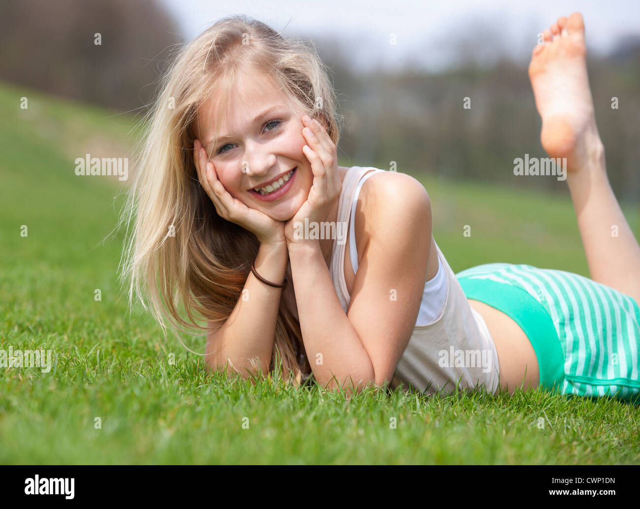 Österreich, Teenage Mädchen liegen auf Wiese, Lächeln, Porträt Stockfoto