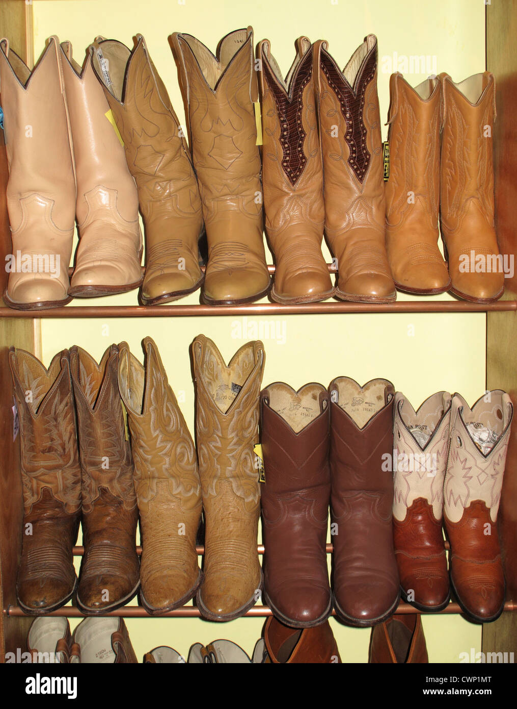 Rack mit Cowboy-Stiefel in Secondhand-Laden Stockfoto
