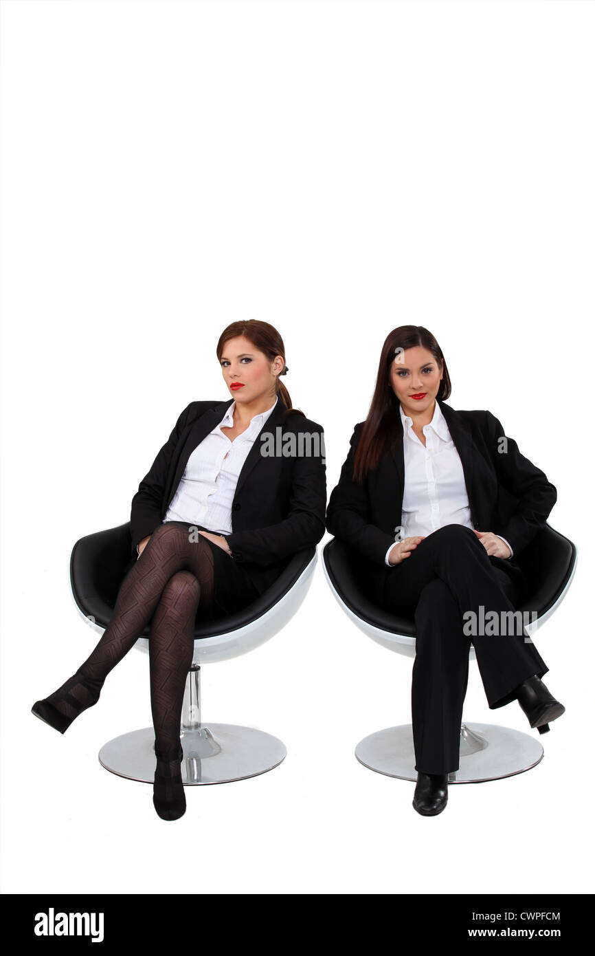Geschäftsfrauen, die nebeneinander sitzen Stockfoto