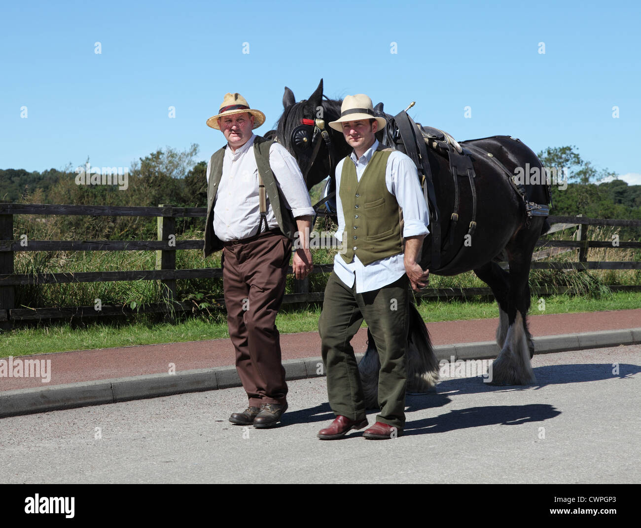 Zwei Landarbeiter gekleidet im Periode Kostüm führen eine schweren Pferd Beamish Museum, Nord-Ost-England, UK Stockfoto