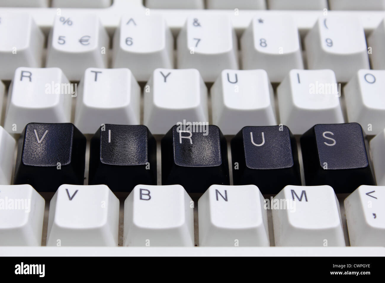 Das Wort VIRUS in schwarzen Buchstaben auf einem weißen Tastatur Stockfoto