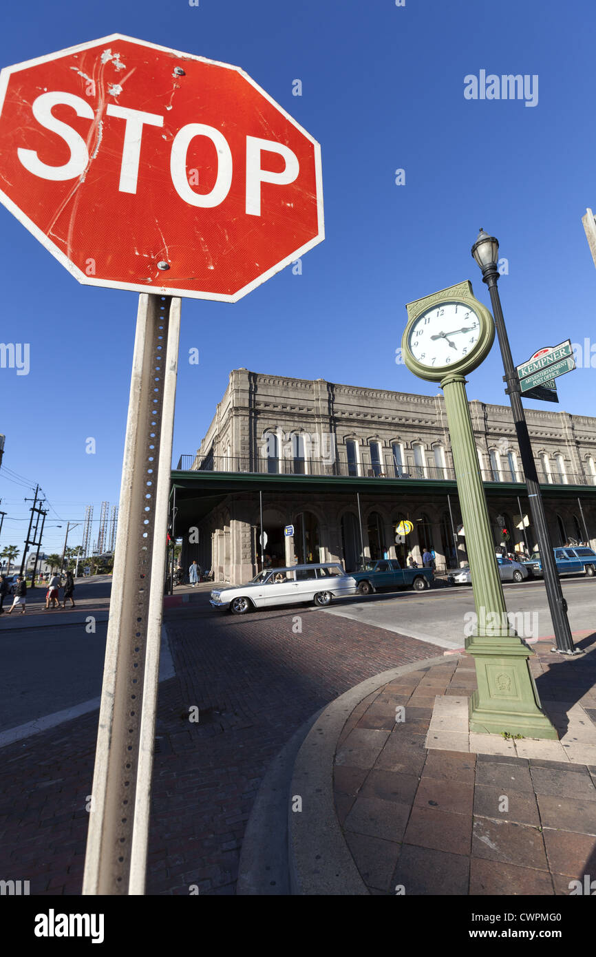 Große Stop-Schild und Uhr, Straßenszene in der historischen Innenstadt von Galveston, Texas, USA Stockfoto