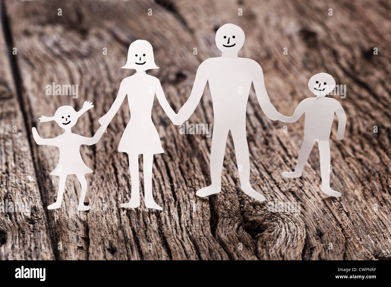 Pappfiguren der Familie auf einem Holztisch. Das Symbol der Einheit und des Glücks. Stockfoto
