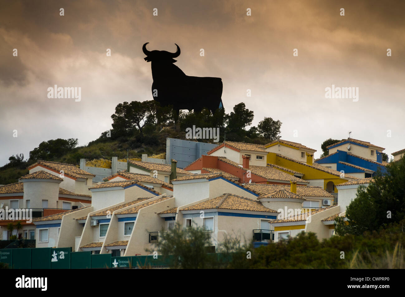 Eine Silhouette cut.out Bull überblickt wohnen am Stadtrand von Benidorm. Stockfoto