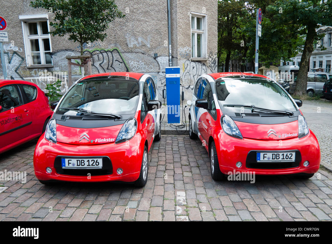 Zwei elektrische Flinkster-Carsharing-Autos Aufladen auf Berliner Straße Deutschland Stockfoto