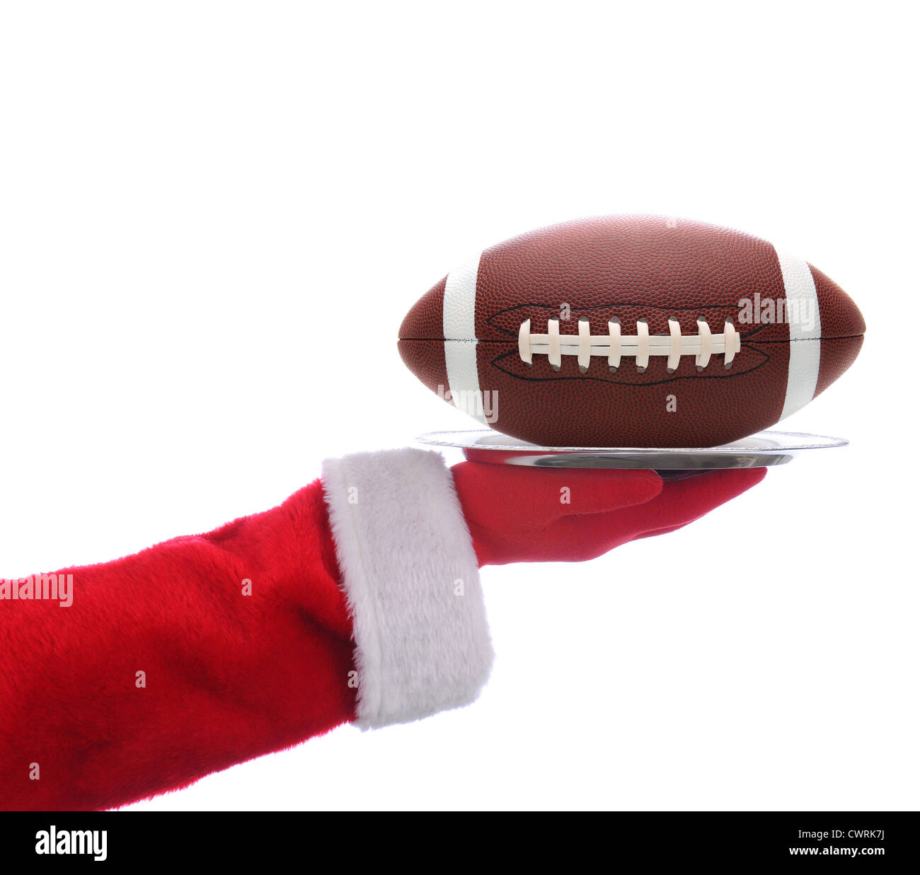 Santa Claus ausgestreckten Arm hält ein American Football auf einem Tablett. Quadratisches Format auf einem weißen Hintergrund. Stockfoto