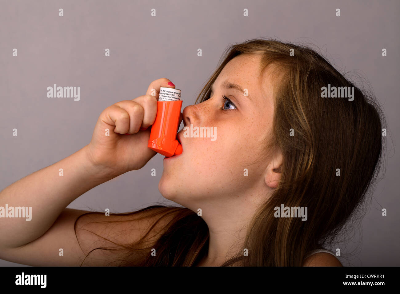 Ein 10 Jahre altes Mädchen mit einer Asthma-Pumpe Stockfoto