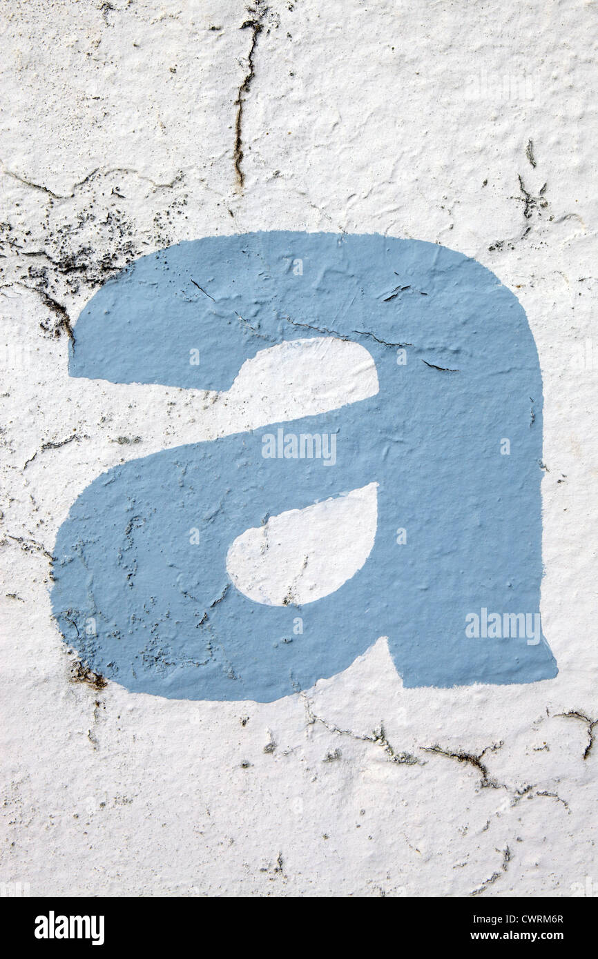 Kleinbuchstaben "a" in Himmelblau Farbe Schablonen auf bröckelt Außenwand, UK. Für andere Buchstaben siehe Nick Sinclair folio Stockfoto