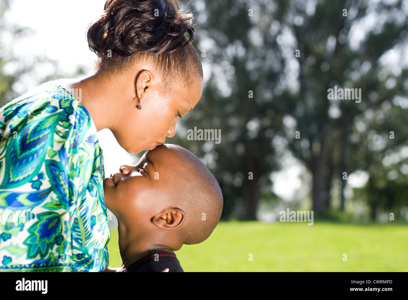 Afrikanische Mutter küssen Sohn im freien Stockfoto