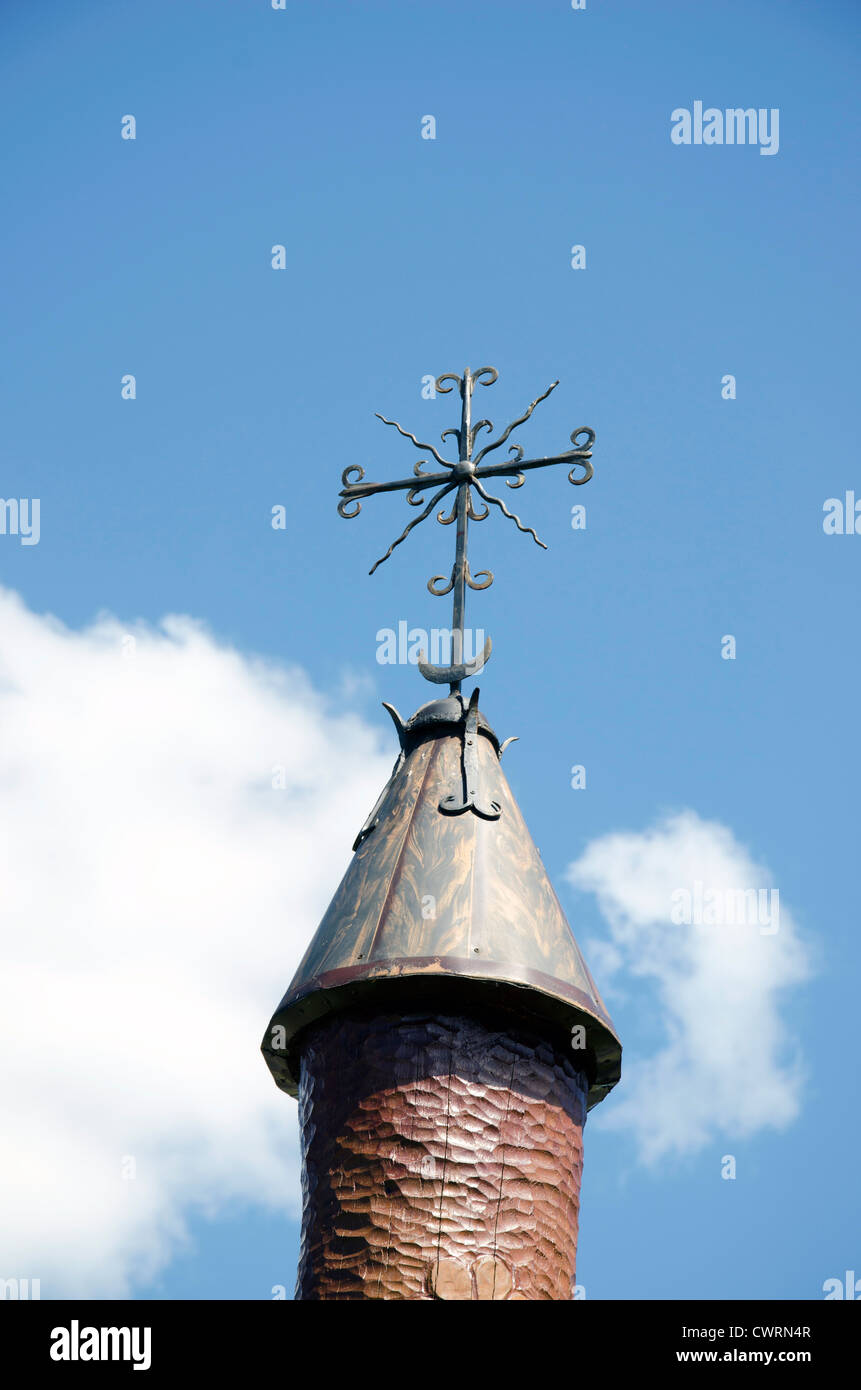 Skulptur geschnitzt aus Holz mit Dach und handgemachte Stahl Dekorationen auf Hintergrund der bewölkten Himmel. Stockfoto
