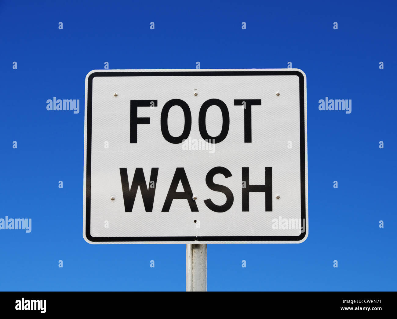 große reflektierende Zeichen Stil Fuß waschen Straßenschild mit blauem Himmelshintergrund Stockfoto